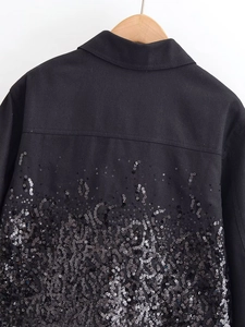 Close-up of black sequin embellishments on the lower back of a winter lapel jacket