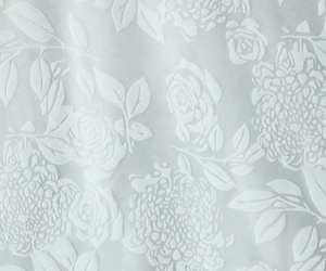 Vue macro du tissu jacquard bleu clair avec motifs de roses en relief et éclat soyeux
