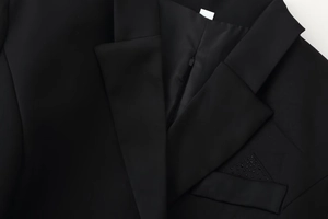 Close-up of black blazer dress with rhinestone pocket detail and peaked lapel