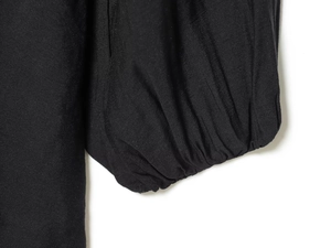 Detail van elegante zwarte pofmouwen met elastische manchetten op een korte jurk