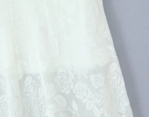 Gros plan sur un tissu en dentelle blanche avec motifs floraux 3D et détails dévoré