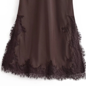 Detail of dark brown satin dress featuring delicate eyelash lace trim and silky texture