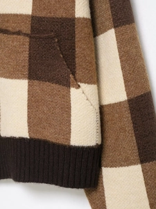 Detail of checkered knit sweater with brown plaid patterns and ribbed hem textures