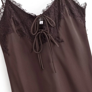 Detail of dark brown satin dress featuring black eyelash lace trim and front tie closure