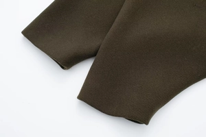 Macro detail of dark olive green wool coat sleeve with premium twill texture