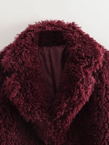Detail shot of wine red faux fur coat showing soft texture and premium inner lining