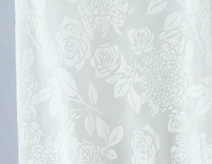 Vue détaillée du tissu en dentelle florale blanche avec broderies de roses et feuilles