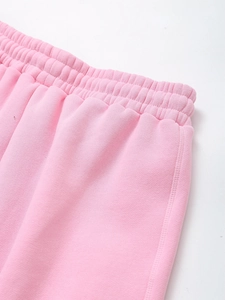 Detail of pink knitted joggers featuring a wide elasticated waistband and reinforced stitching