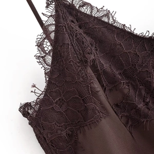 Close-up of eyelash lace trim and satin fabric detail on a dark brown slip dress