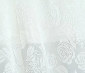 Détail macro de dentelle rose avec motifs floraux sur le tissu de la robe blanche