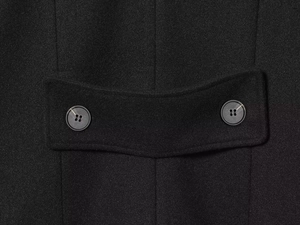 Detail of black wool coat featuring waist adjustment strap with two four-eye buttons