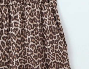 Close-up of leopard print bodysuit showing elastic gathered waist and side pocket detail