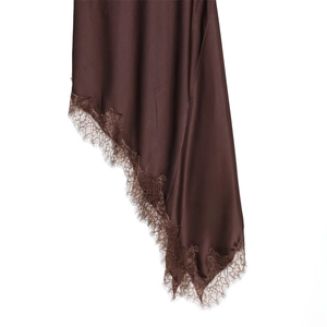 Détail de robe en satin de soie chocolat avec ourlet asymétrique et bordure en dentelle