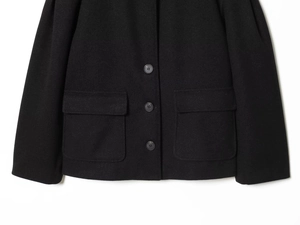 Detail of black wool jacket featuring high-quality buttons and large flap pockets