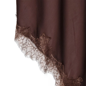 Détail de l'ourlet de la robe en satin marron avec dentelle délicate et texture soyeuse
