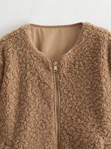 Close-up of deep brown fleece jacket with V-neck and light gold metal zipper detail