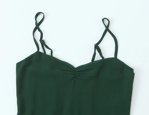 Dettaglio dell'abito verde scuro con spalline regolabili e scollo a V plissettato