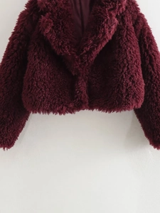 Detail view of deep burgundy faux fur jacket with wide lapels and smooth satin lining