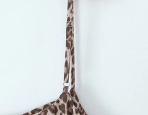 Detail of adjustable thin shoulder strap with silver buckle on leopard print bodysuit
