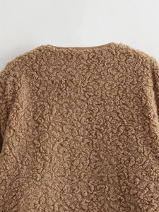 Macro shot of brown fleece texture and collar stitching on a cozy teddy jacket