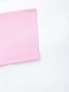 Close-up of light pink ribbed knit fabric texture of the three-piece cardigan set