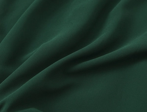 Dettaglio del tessuto in chiffon verde scuro con trama fine e drappeggio elegante