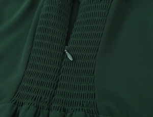 Dettaglio dell'abito verde scuro con cerniera invisibile e texture elastica a punto smock