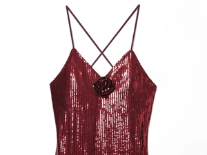 Detail of wine red sequined dress with deep V-neck and handmade floral accent