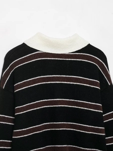 Dettaglio del collo alto a costine e della morbida trama in maglia a righe del maglione