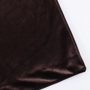 Gros plan détaillé montrant la texture lisse et le reflet riche du tissu en velours marron