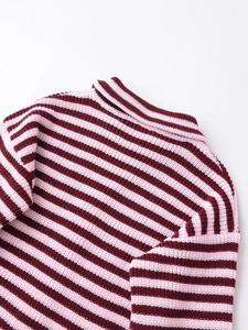 Détail du pull en maille rayé bordeaux et rose montrant la texture côtelée et le col
