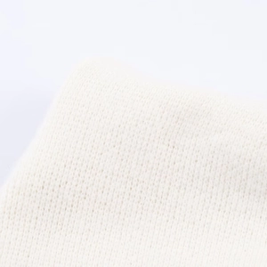 Macro detail of the fine knit texture and soft off-white wool fabric on the women top