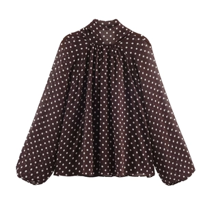 Detailansicht der Schluppenbluse mit Stehkragen und elegantem weißen Punktemuster