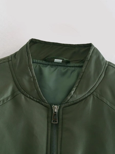 Détail du col d'un blouson aviateur vert foncé avec fermeture éclair en métal argenté et nylon
