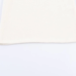 Detailed macro view of the finely knitted hem and white fabric texture of the women top