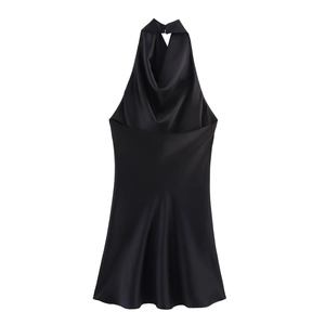 Detail of elegant black satin halter neck dress with draped neckline and backless design