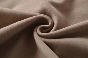 Detailed macro shot of premium beige suede fabric texture with soft and thick layering