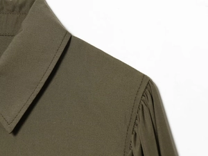 Detail of army green poplin shirt showing classic collar and elegant puffed sleeve pleats