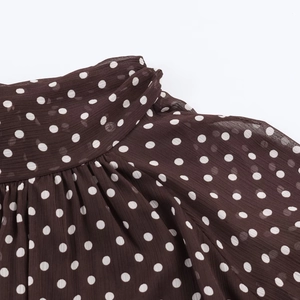 Detailansicht von braunem Polka-Dot-Chiffon mit feinen Falten und leichter Textur