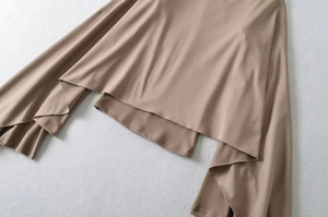 Detail view of khaki suede top showing the asymmetrical layered hem and draped fabric texture