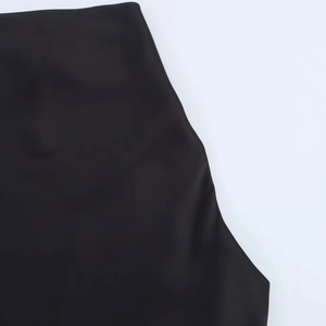 Detail shot of the silky black fabric and elastic waistline of the backless satin dress