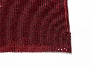 Close-up of wine red sequin fabric detailing with vertical stripe pattern on the dress