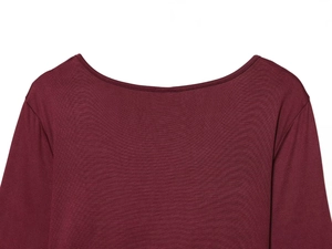 Detailed macro view of burgundy long sleeve top showing ribbed texture and neat stitching