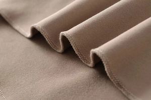Detailed view of camel brown knit fabric with premium stitching on slim fit velvet top