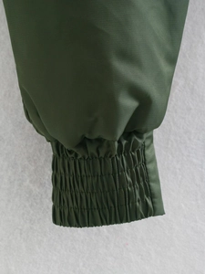 Détail du poignet élastique d'un blouson aviateur vert foncé avec texture de tissu