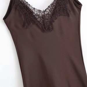 Detail of the V-neckline featuring intricate dark brown lace trim on a satin dress