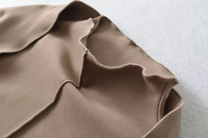 Macro detail of mocha suede top showing wavy ruffle edges and fine stitching