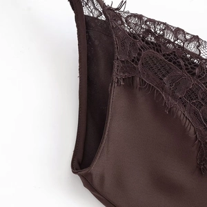 Detailed close-up of dark brown satin dress with intricate eyelash lace trim and silk texture