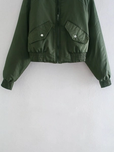 Détail du bomber vert olive avec fermeture éclair et grandes poches à rabat et boutons en métal
