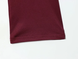 Macro detail of high-density knitted fabric and double-needle stitching in deep burgundy
